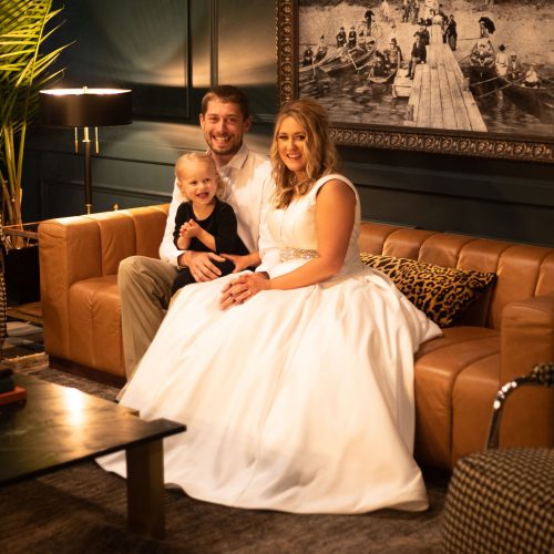 Happy couple poses in front of old portrait